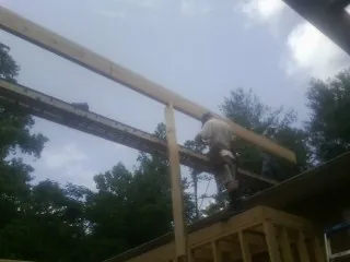 Carpenter setting a ridge beam over a new addition frame — Ice Dam Removal by Roofing Brothers in Wisdom