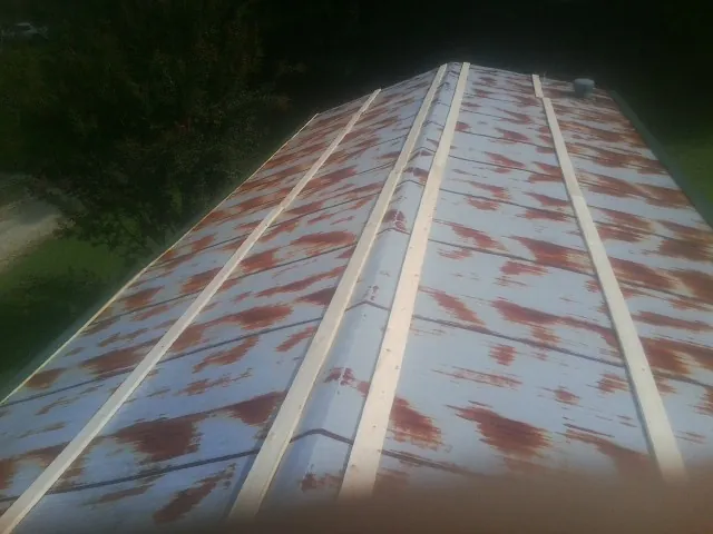 Rusted metal roof panels with new wood purlins before replacement — Storm Damage Roof Repair in Wisdom by Roofing Brothers